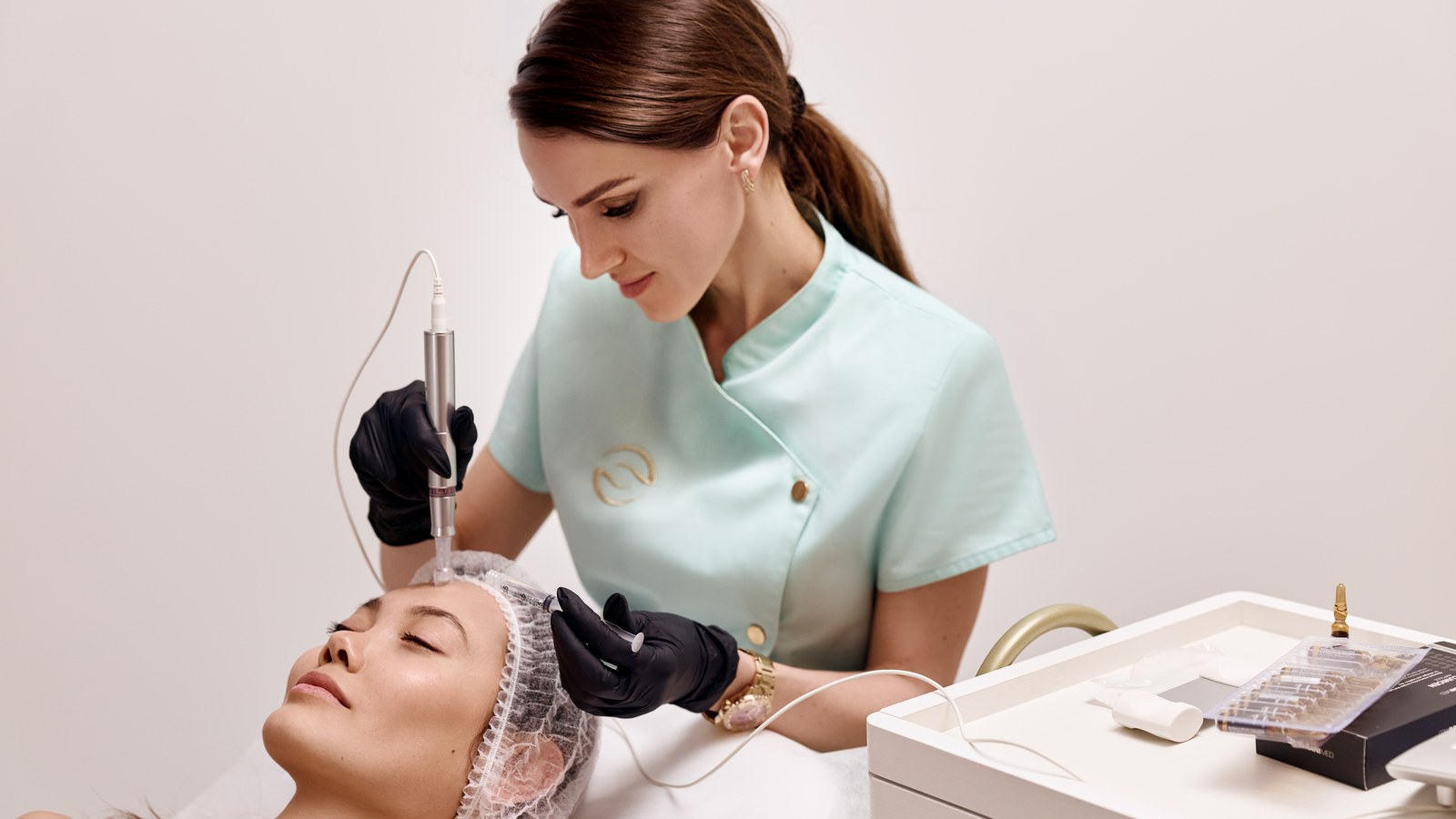 A Bogat specialist performing microneedling on a client's face with a pen device